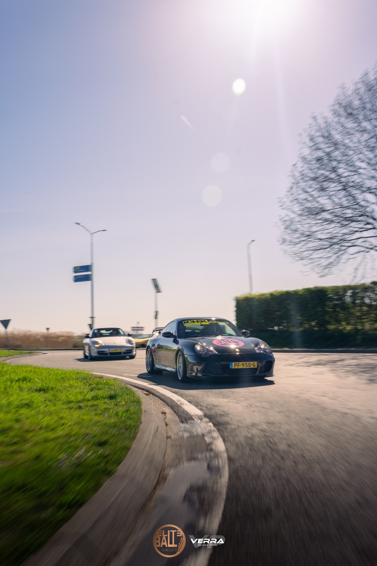 Porsche 911's nemen een rotonde tijdens Eliteball Rally