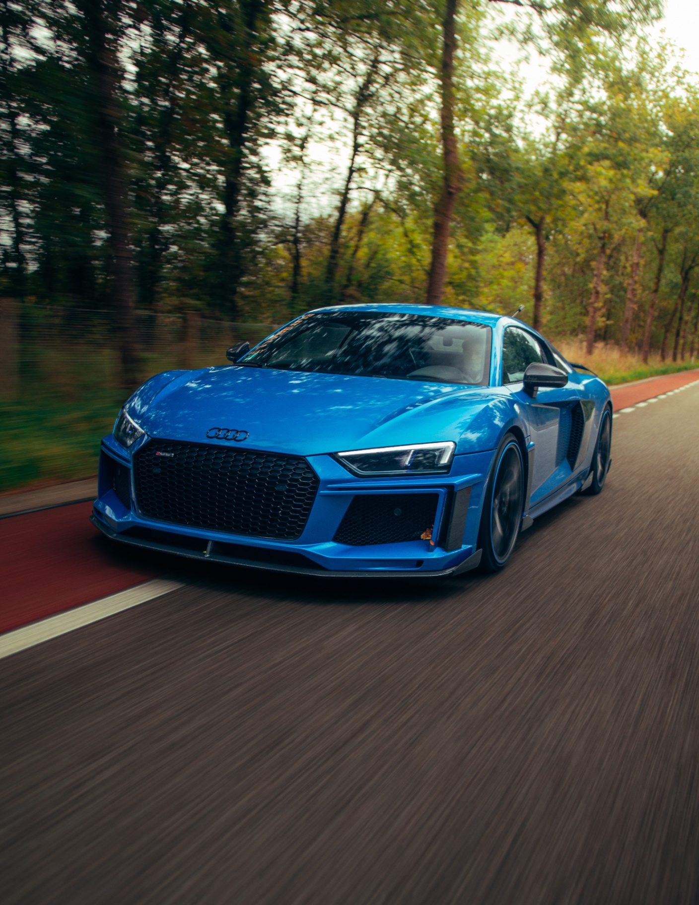 Blauwe Audi R8 in actie op landweg met motion blur